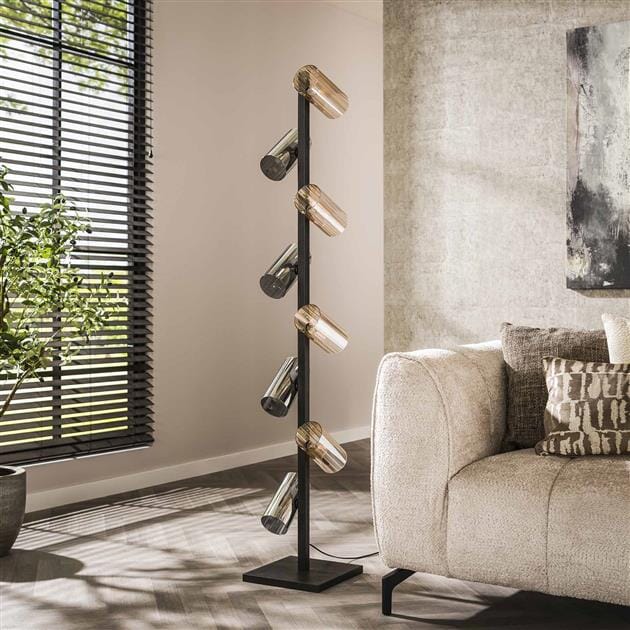 Le lampadaire industriel illuminant un salon moderne.