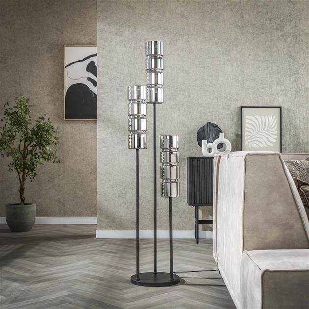 Jeu de lumière subtil diffusé par les abat-jours en verre fumé dans un coin lecture.