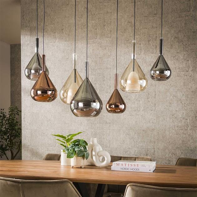 Suspension design vintage avec abat-jours en verre ambre illuminant une cuisine contemporaine.