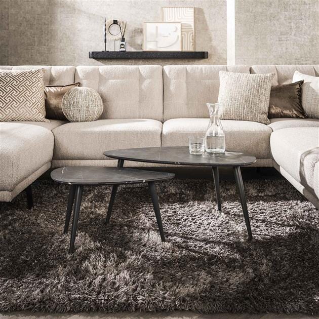 Table basse design noir en forme de poire dans un salon moderne.