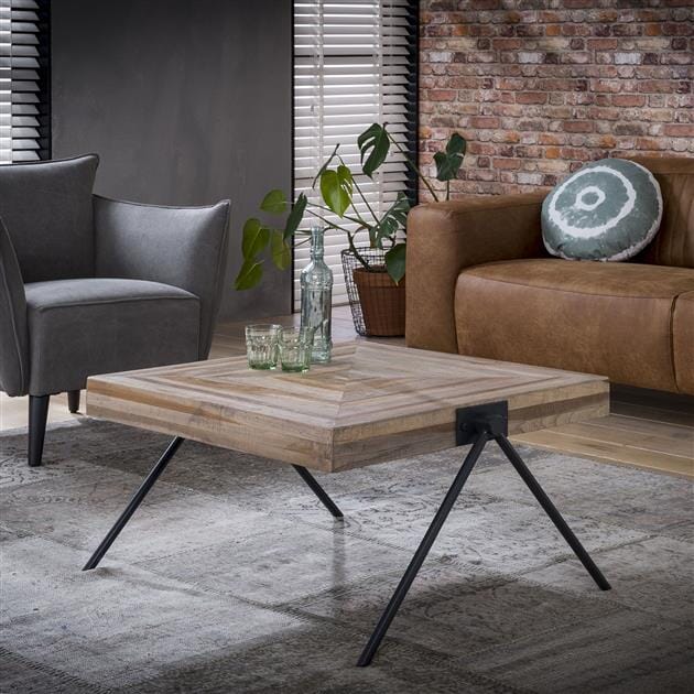 Table en teck recyclé et acier dans un salon contemporain.