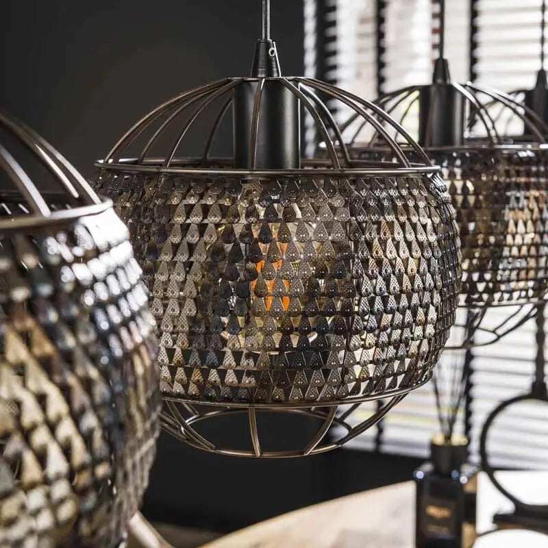 Détail artisanal: vue rapprochée des petits trous semi-transparents dans les abat-jours, diffusant la lumière de manière subtile