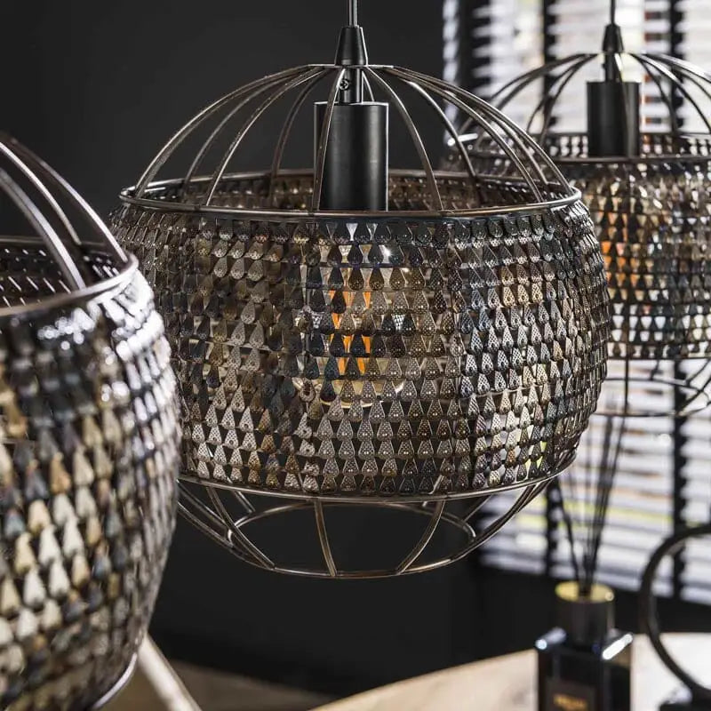 Un gros plan mettant en valeur les détails artisanaux de la fabrication de la suspension industrielle "Armor".