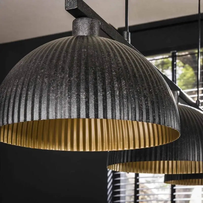 Un gros plan mettant en valeur les détails nervurés des abat-jours de la suspension.