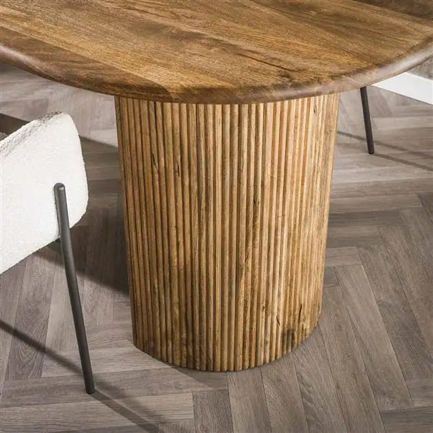 Détail des pieds demi-lune de la table à manger bois clair au design unique.