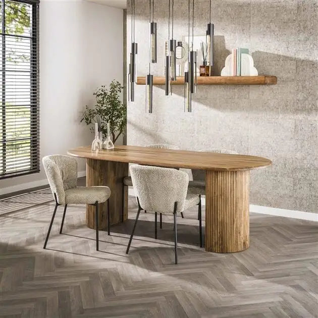 Table à manger bois clair en manguier avec pieds demi-lune et plateau arrondi.