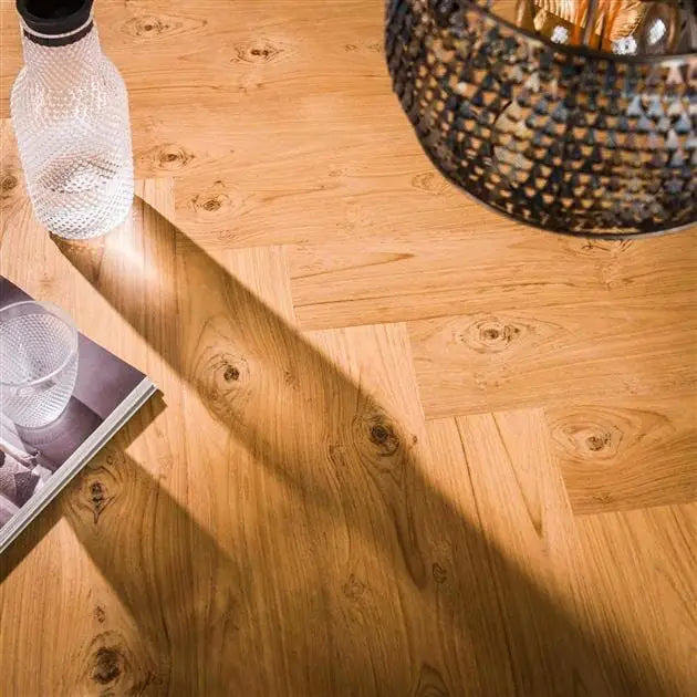 Vue rapprochée du motif à chevrons sur le plateau en teck de la table oval.