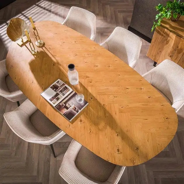 Table à manger oval en teck avec structure en acier dans une salle à manger moderne.