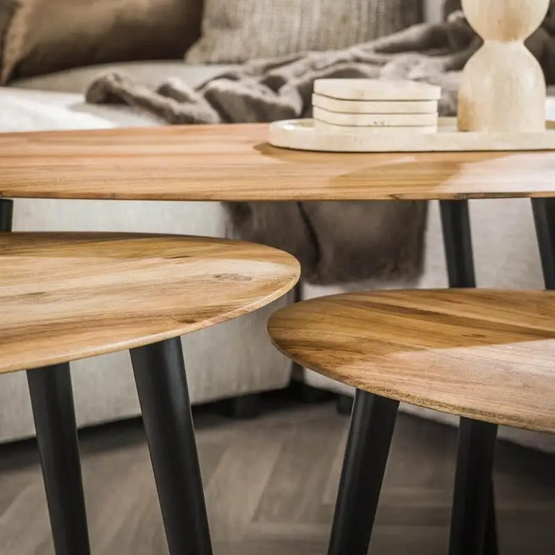 Vue rapprochée du plateau légèrement incliné de la plus grande table d&#39;appoint, mettant en valeur la texture et la couleur naturelle du bois d&#39;acacia.