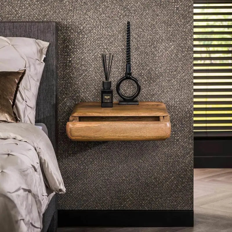 Gros plan sur la fixation murale de la table de chevet, montrant sa discrétion et sa solidité.