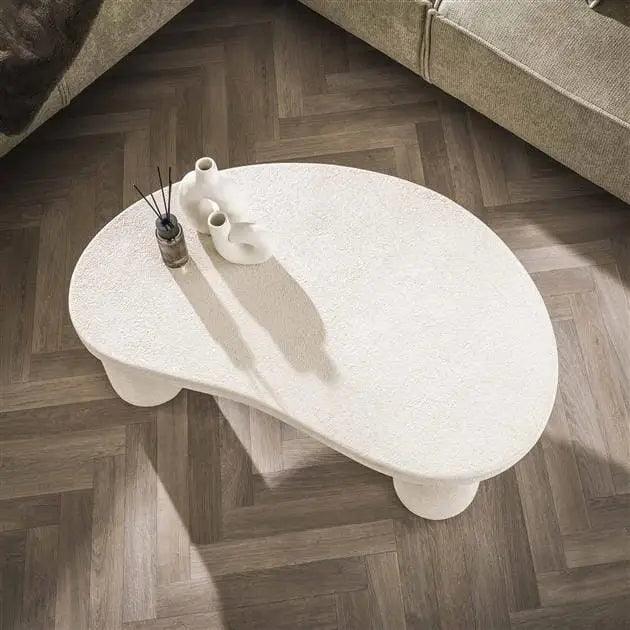 Vue latérale de la table de salon design de luxe montrant les détails raffinés des pieds en métal doré et le plateau en marbre blanc.